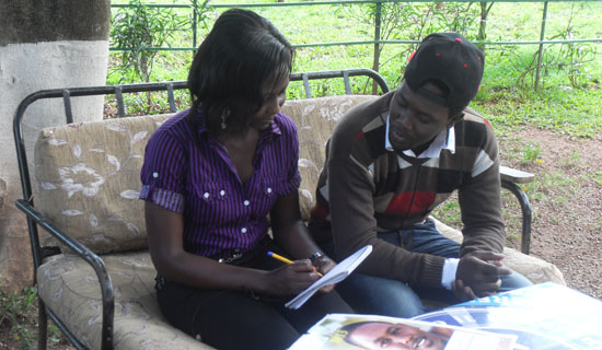 Niki Nola and his fan Betty Nazziwa discuss his music career. PHOTO BY ISAAC SSEJJOMBWE