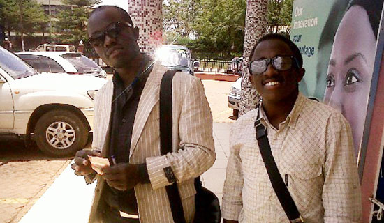Cricket star Kyobe (right) with fan, Mugabi. PHOTO BY ISAAC SSEJJOMBWE