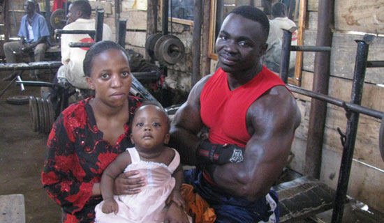 Cobra i s back on his feet after the 2010 shooting. He poses with his wife and child in his gym. PHOTO BY JUDE KATENDE