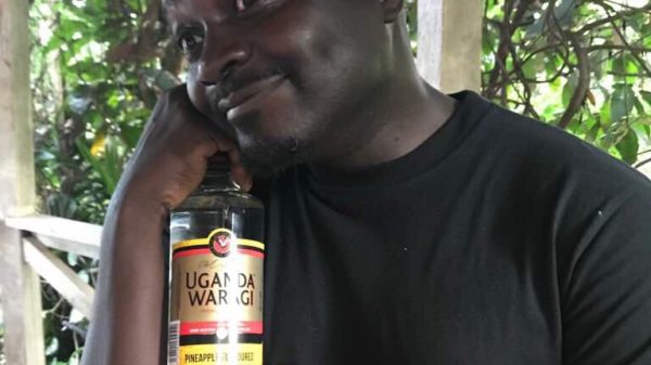 Dibo Nakuzambwa Brown poses with a photo of Uganda Waragi Pineapple flavour