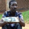 Qute Kaye holding teh headlight he allegedly stole from a car in Busega on Thursday