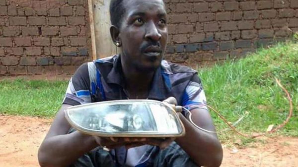 Qute Kaye holding teh headlight he allegedly stole from a car in Busega on Thursday